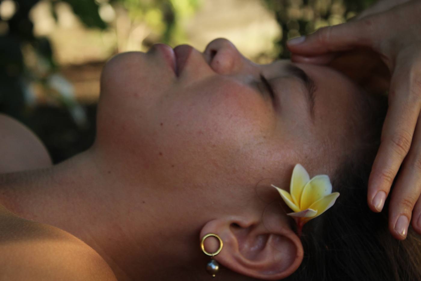 Massage du visage, relaxation profonde avec fleur de frangipanier